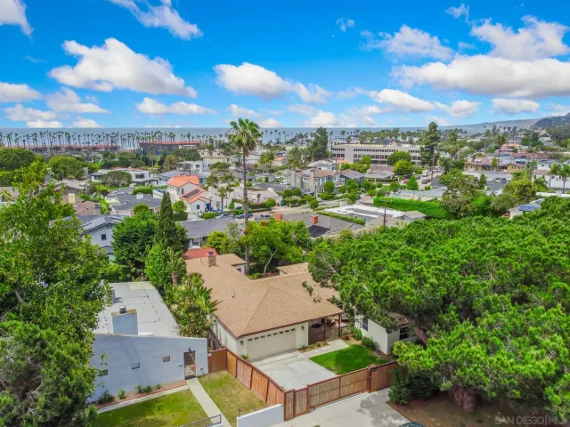 an aerial view of residential houses with outdoor space and trees