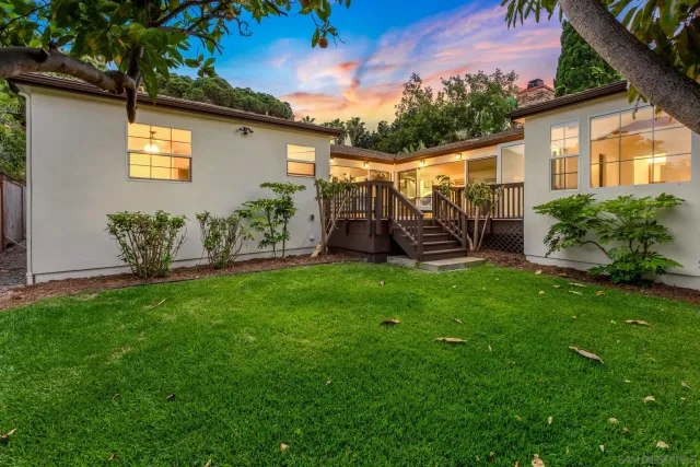 a view of a chair and table in backyard of the house