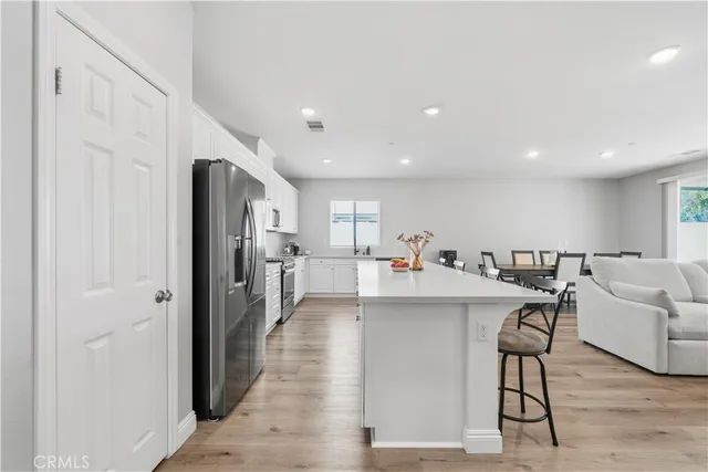 a open kitchen with white cabinets and stainless steel appliances