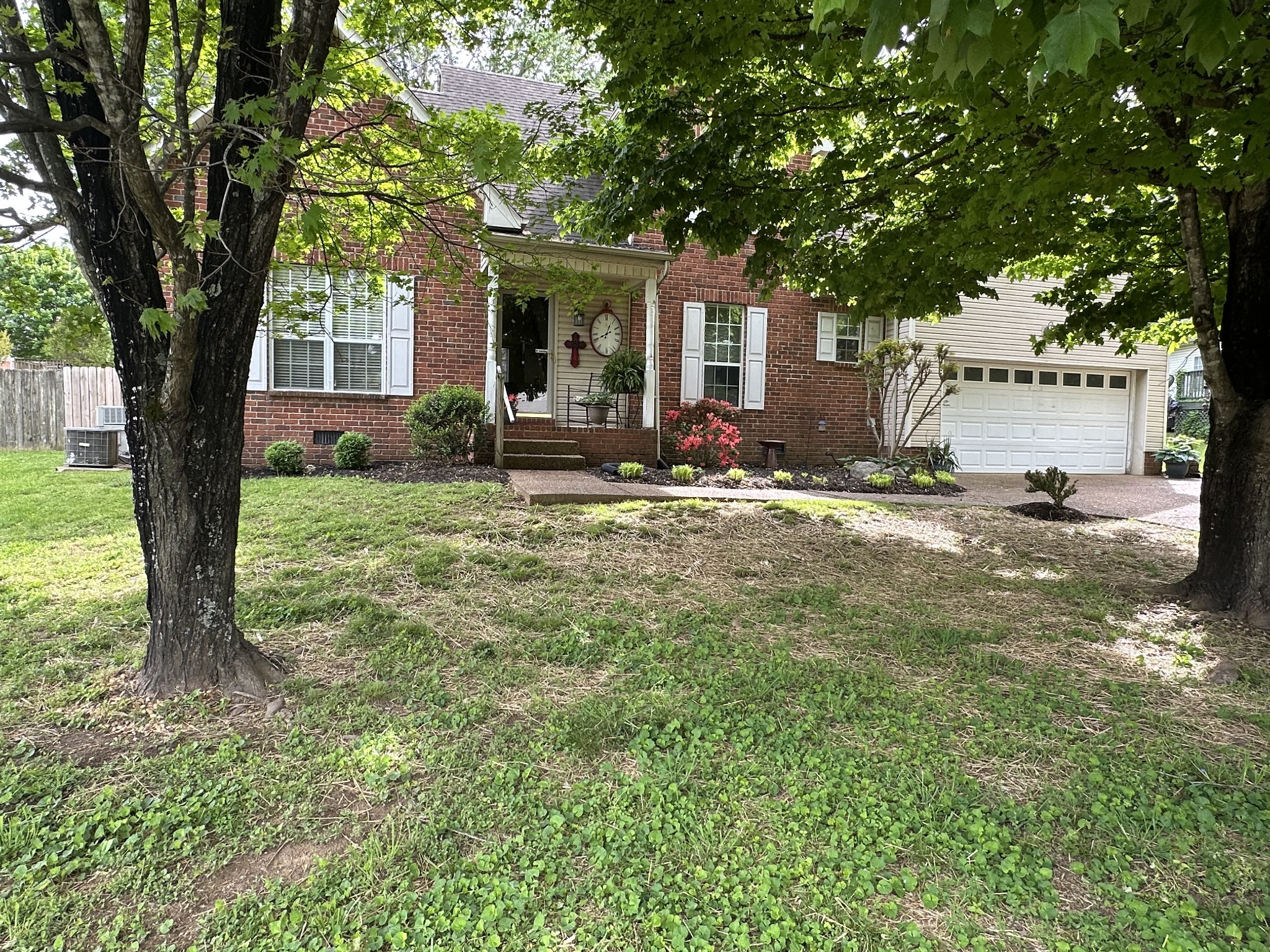 a view of a house with backyard and a tree