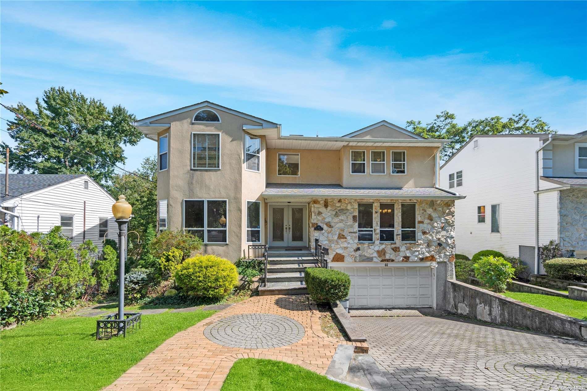 a front view of a house with a yard and potted plants