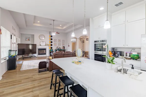 a kitchen with stainless steel appliances kitchen island granite countertop a sink a stove a dining table and chairs