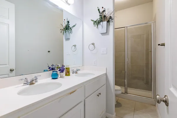 a bathroom with a shower sink vanity and mirror
