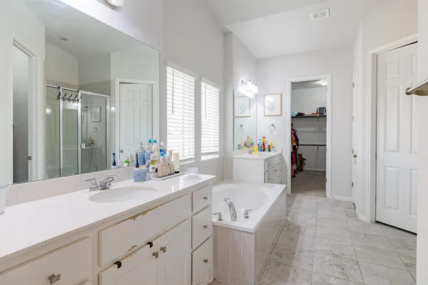 a spacious bathroom with a shower sink and a mirror