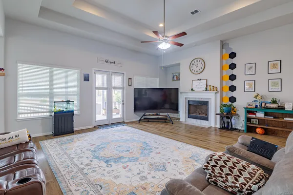 a living room with furniture a flat screen tv and a fireplace