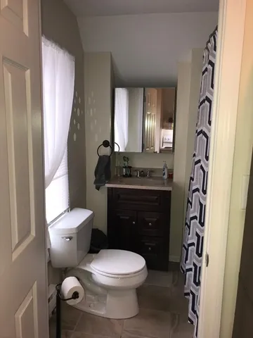 a bathroom with a granite countertop toilet sink and mirror