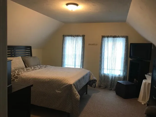 a bedroom with a bed and a television