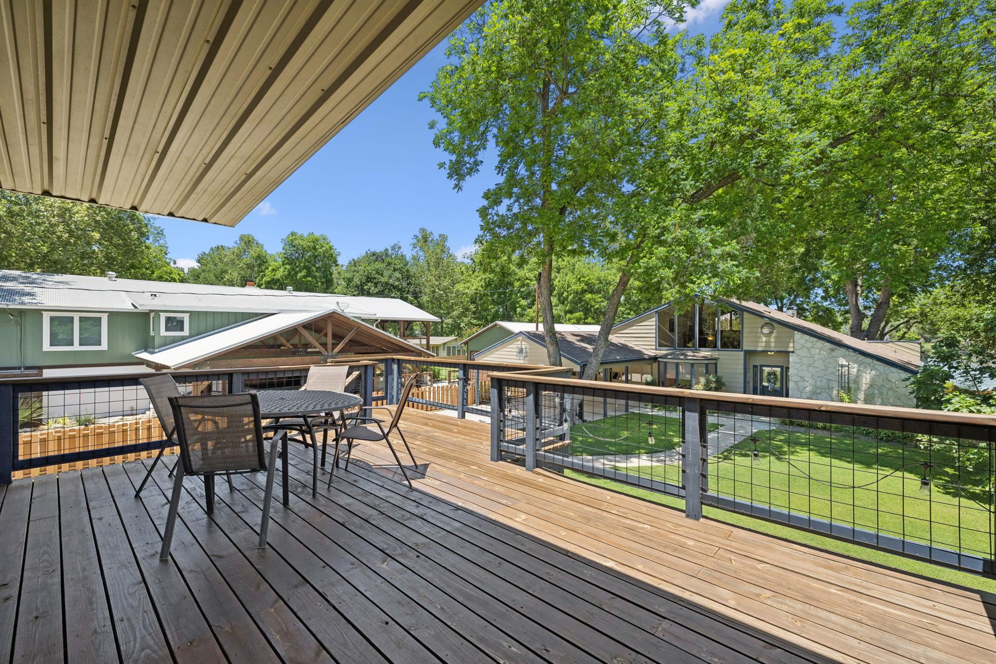 1435 East Zipp Road New Braunfels, TX 78130 - Photo 39 of 43 a view of a roof deck with table and chairs a barbeque with wooden floor and fence