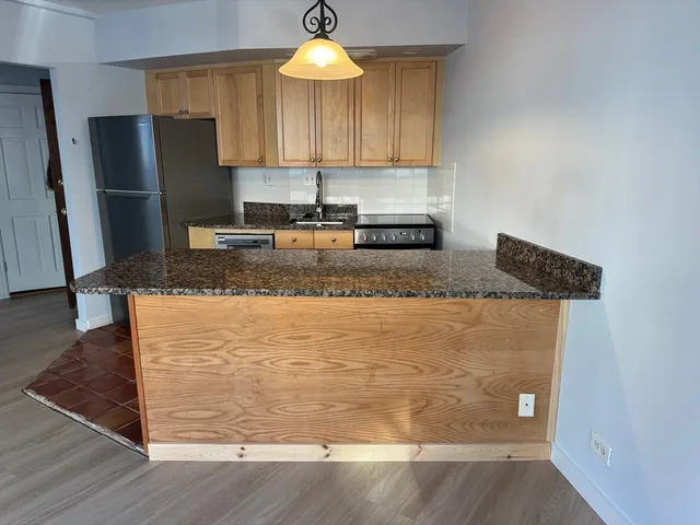 a kitchen with stainless steel appliances granite countertop a sink refrigerator and microwave