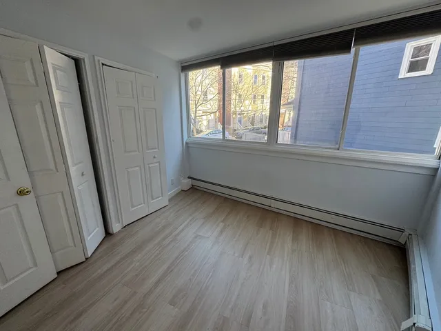 a view of a room with wooden floor and window