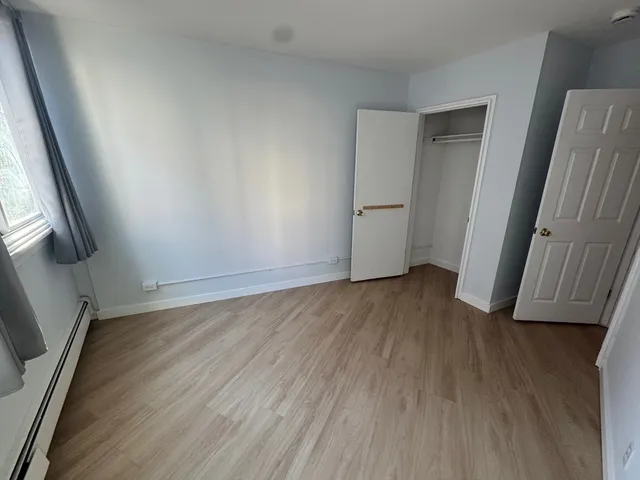 an empty room with wooden floor and door