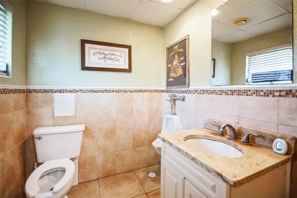 a bathroom with a granite countertop sink a mirror and a toilet
