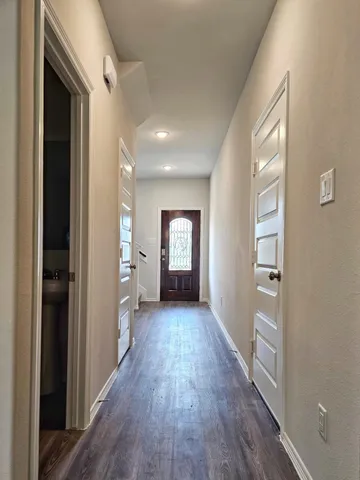 a view of a hallway with wooden floor and closet