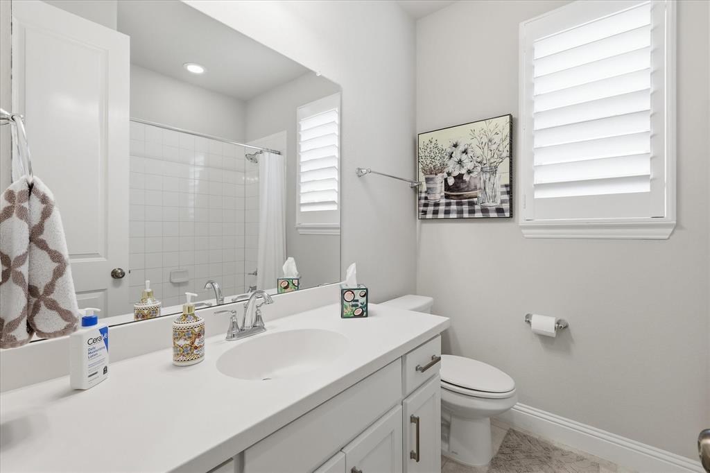 9708 Surveyor Road Oak Point, TX 75068 - Photo 29 of 34 Bathroom featuring a white vanity with an integrated sink, polished chrome faucet, and white countertop