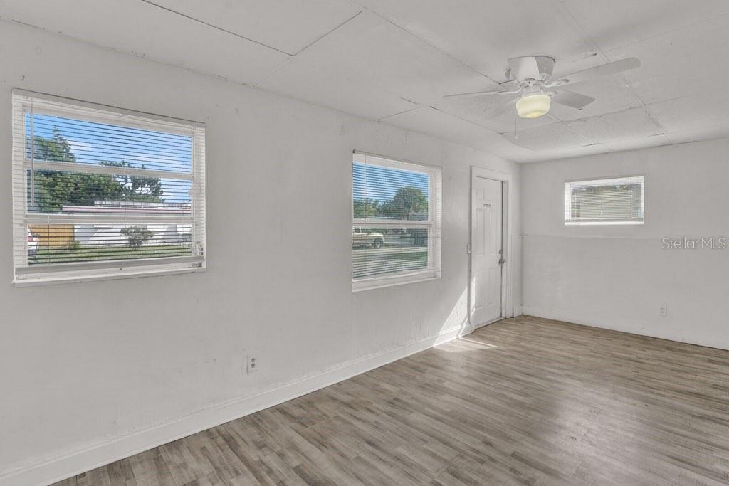 7871 Terrace Road Lantana, FL 33462 - Photo 7 of 19 a view of an empty room with wooden floor and a window