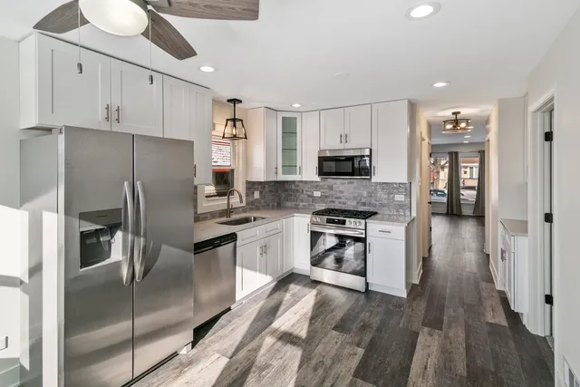 a kitchen with stainless steel appliances a refrigerator sink and microwave