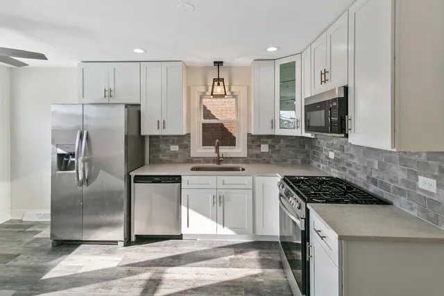 a kitchen with stainless steel appliances granite countertop a stove refrigerator sink and microwave