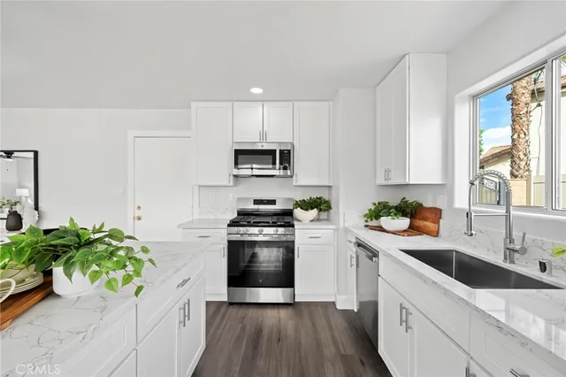 a kitchen with a stove cabinets a dining table and chairs with wooden floor