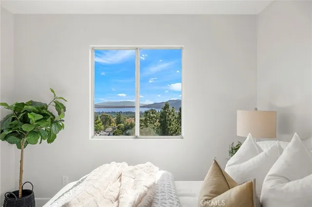 a bedroom with a large bed and a potted plant