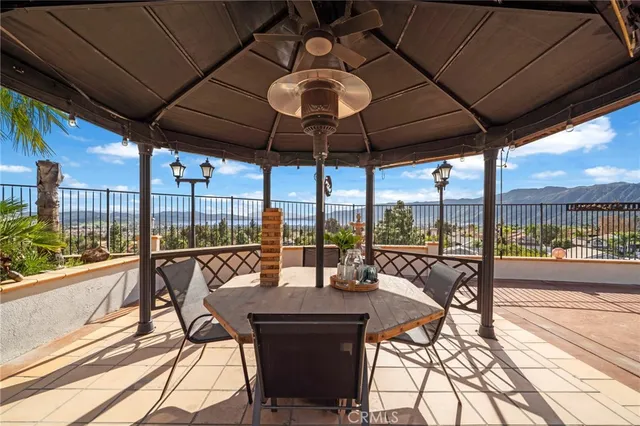 a patio with a table and chairs and potted plants