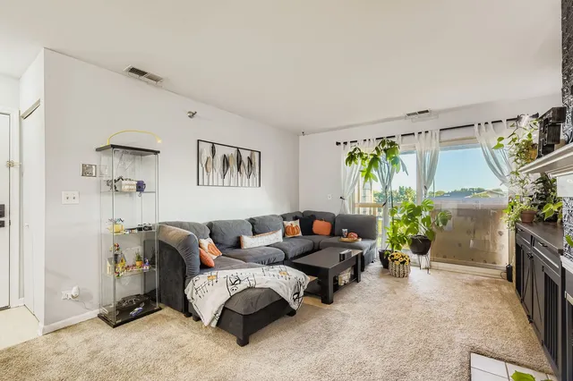 a living room with furniture a window and gym equipment