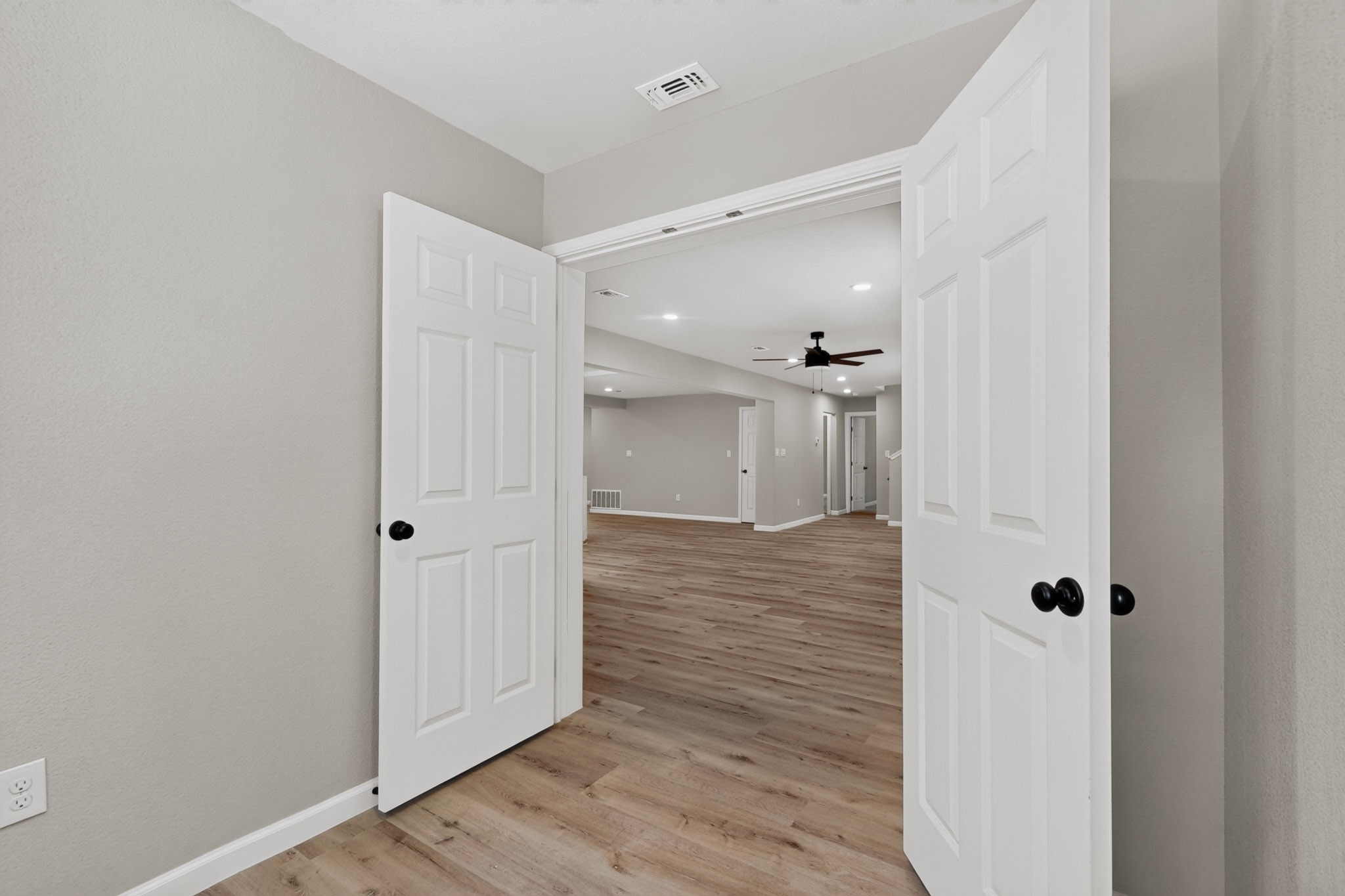 158 Fealy Road Red Rock, TX 78662 - Photo 18 of 40 Double doors open to reveal a spacious living area accented by continuous wood floors.