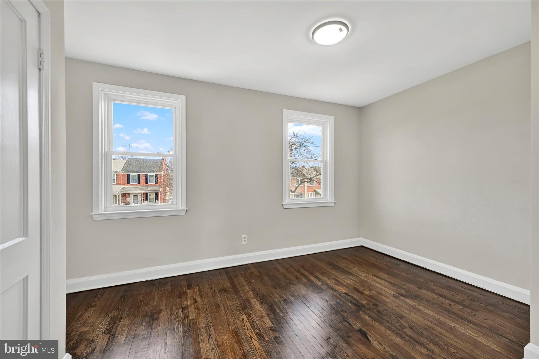 54 Wiltshire Road Essex, MD 21221 - Photo 15 of 22 an empty room with wooden floor and windows