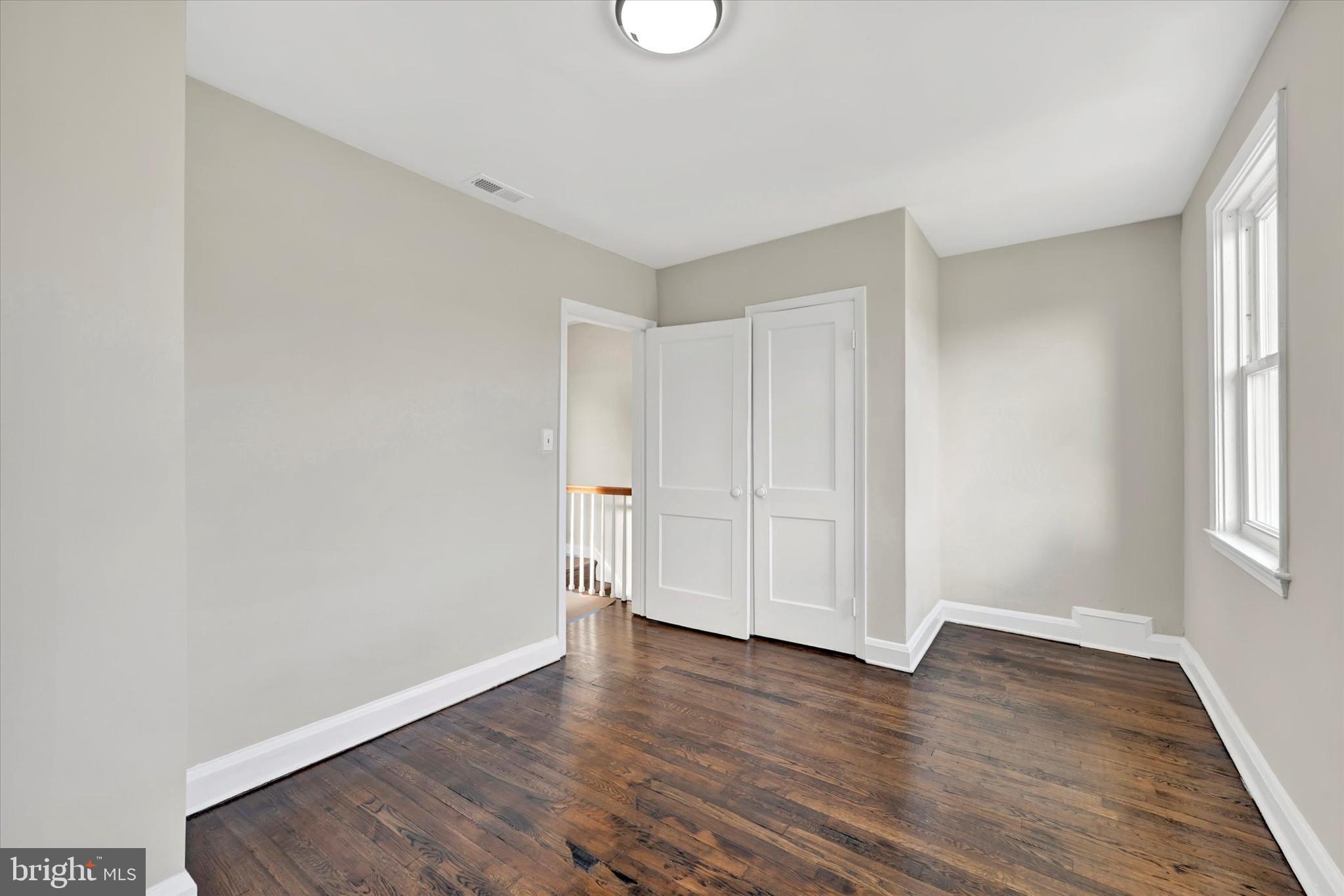 54 Wiltshire Road Essex, MD 21221 - Photo 16 of 22 a view of an empty room with wooden floor and a window