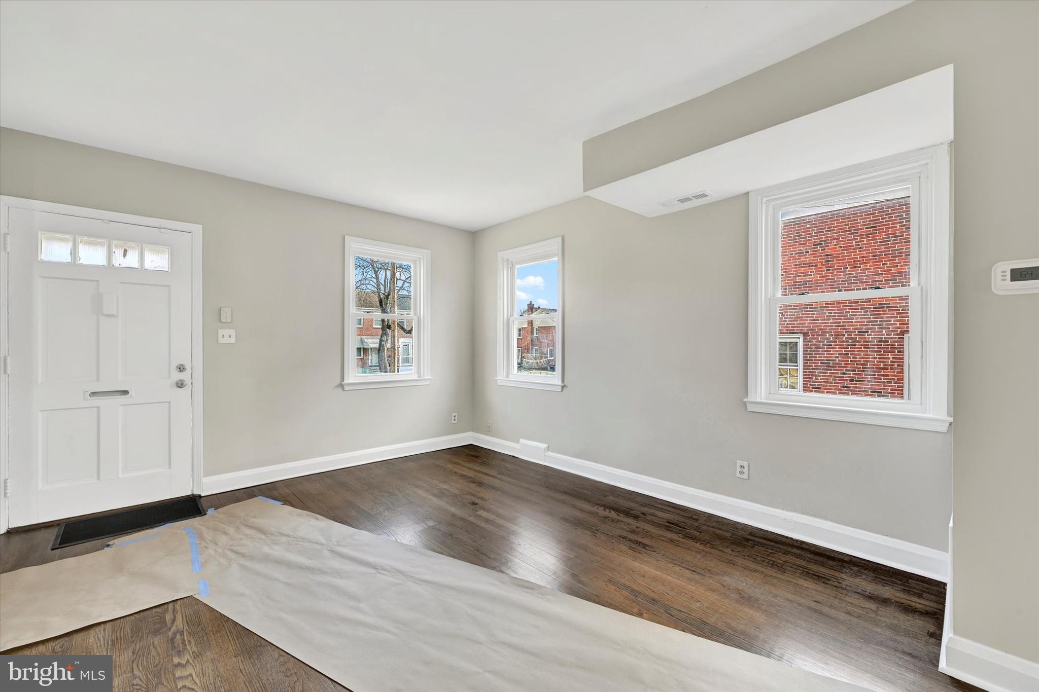54 Wiltshire Road Essex, MD 21221 - Photo 4 of 22 a view of an empty room with wooden floor and a window