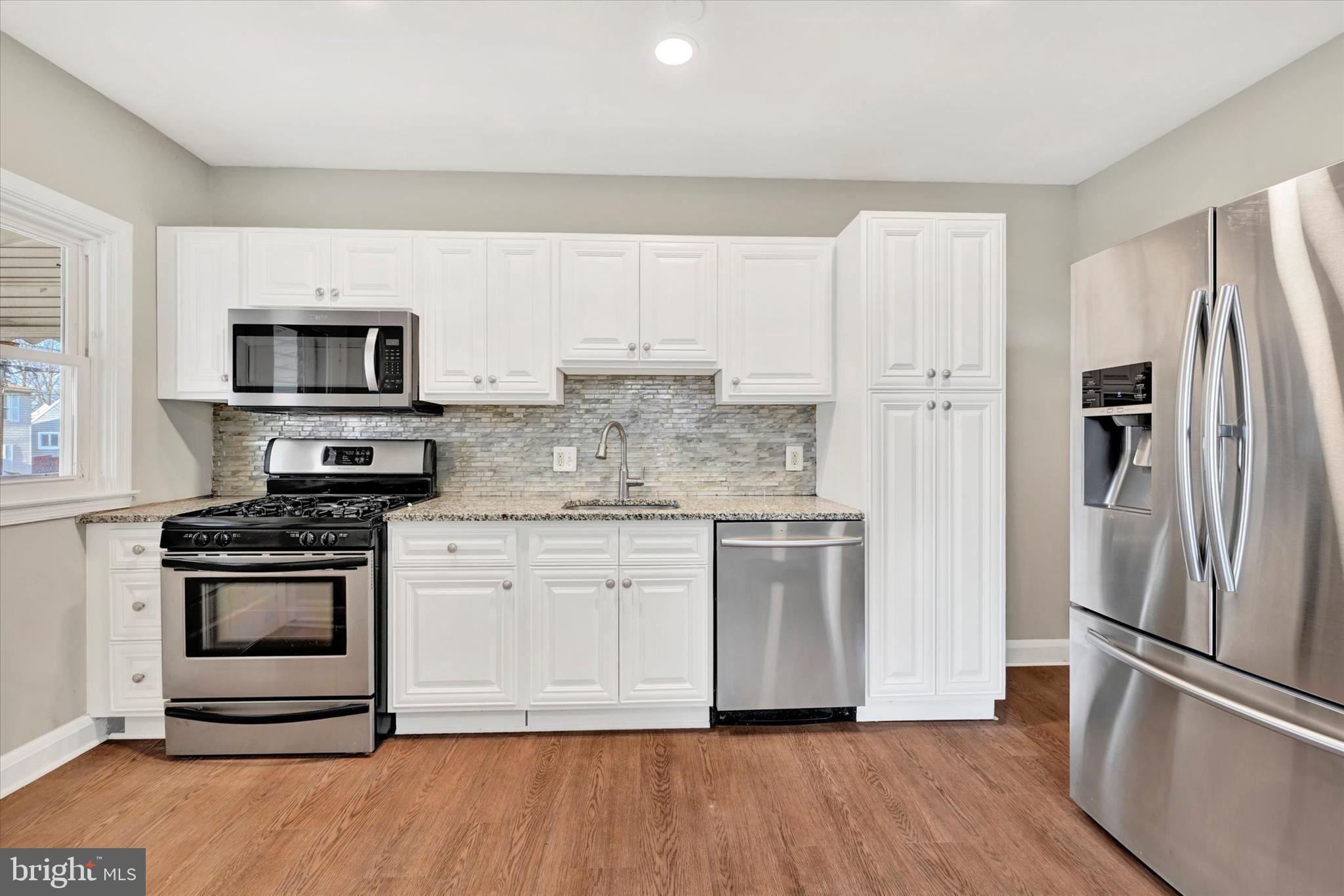 54 Wiltshire Road Essex, MD 21221 - Photo 7 of 22 a kitchen with stainless steel appliances granite countertop a stove a refrigerator and a microwave oven