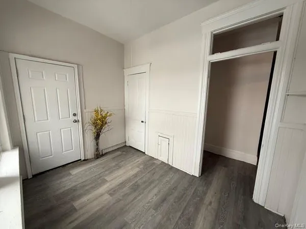 an empty room with wooden floor and closet
