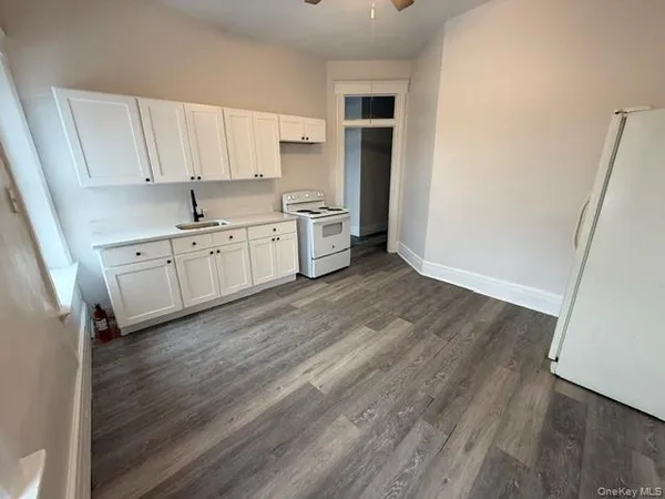 a kitchen with granite countertop white cabinets and white appliances