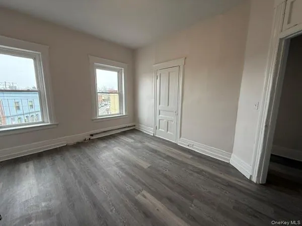 an empty room with wooden floor and window