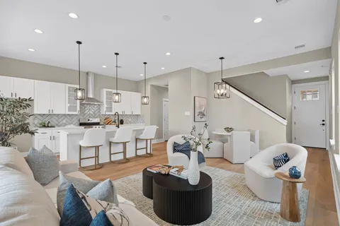 a living room with furniture kitchen and a chandelier