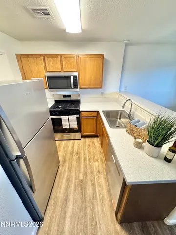 a kitchen with a sink a counter top space and stainless steel appliances