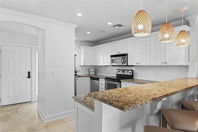 a kitchen with kitchen island granite countertop wooden cabinets and stainless steel appliances