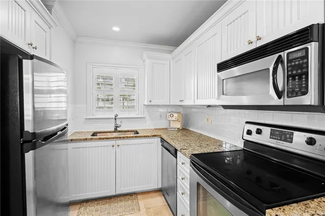 a kitchen with a sink stove and microwave