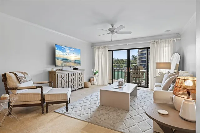 a living room with furniture floor to ceiling window and a flat screen tv