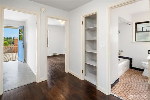 a view of a hallway with wooden floor and closet