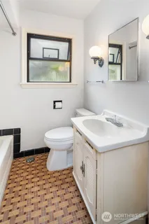 a bathroom with a sink a toilet and mirror