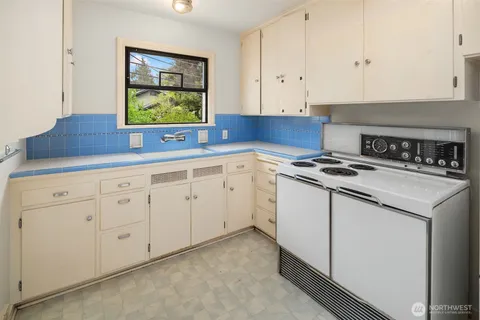a kitchen with white cabinets and white appliances