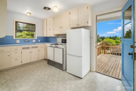 a kitchen with white cabinets and white appliances