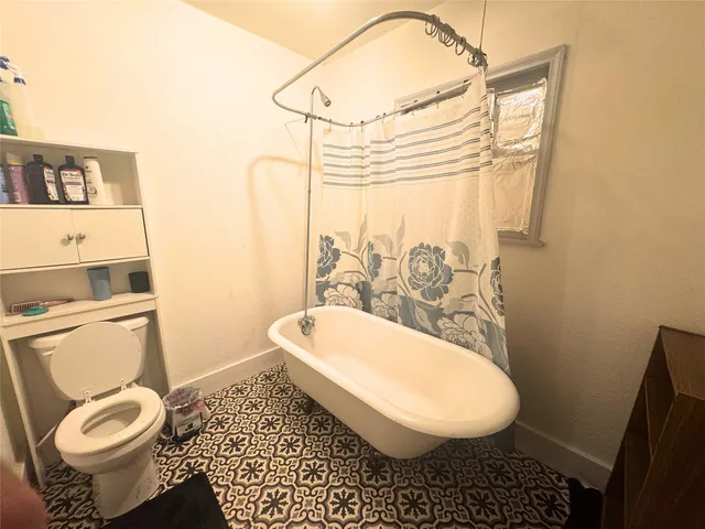 a bathroom with a toilet a sink and mirror