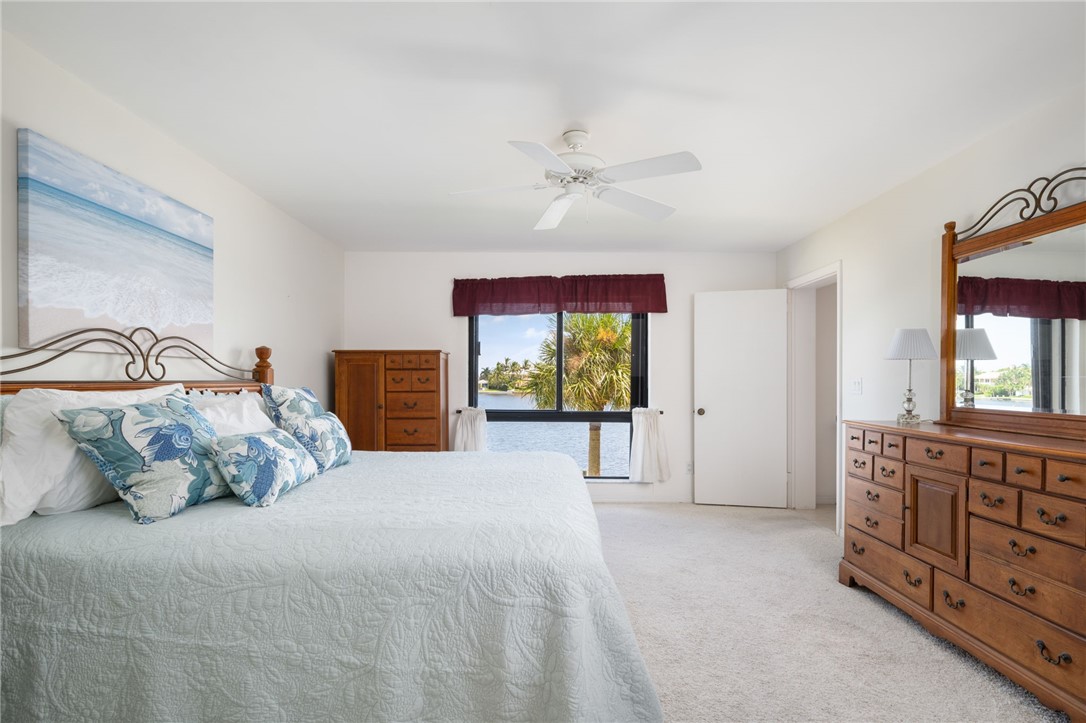 1870 Bay Road, Unit 213G Vero Beach, FL 32963 - Photo 15 of 36 a spacious bedroom with a bed a dresser and a window