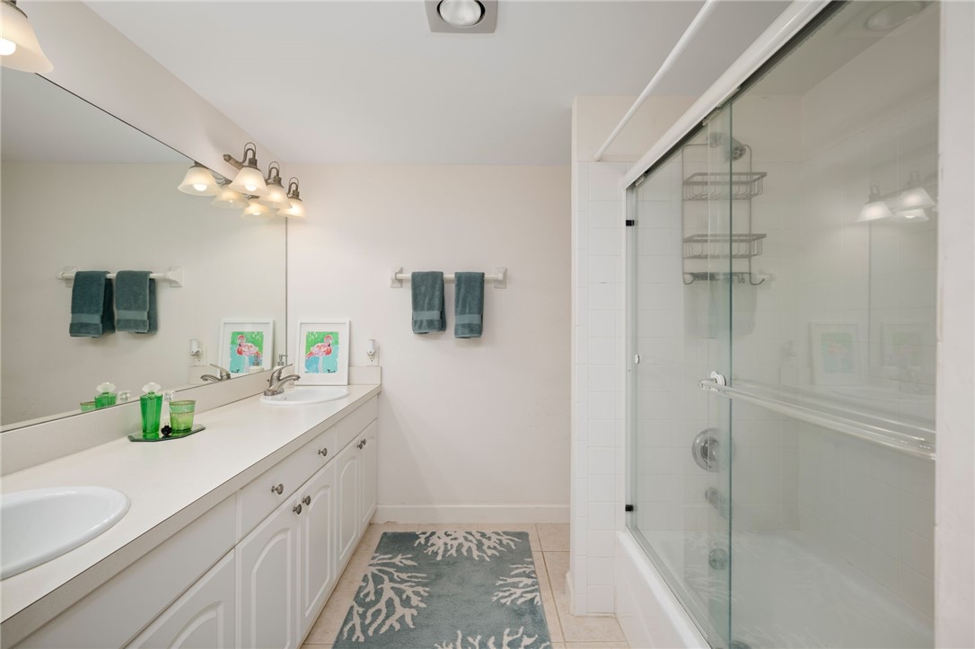1870 Bay Road, Unit 213G Vero Beach, FL 32963 - Photo 18 of 36 a spacious bathroom with a double vanity sink a large mirror and shower