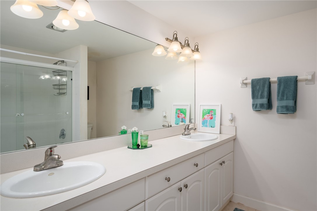 1870 Bay Road, Unit 213G Vero Beach, FL 32963 - Photo 19 of 36 a bathroom with a sink a mirror and vanity