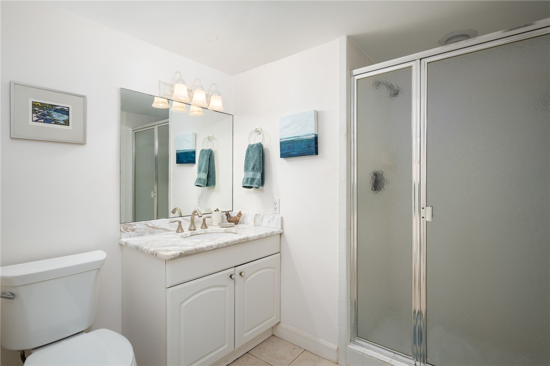 1870 Bay Road, Unit 213G Vero Beach, FL 32963 - Photo 22 of 36 a bathroom with a sink toilet vanity and shower
