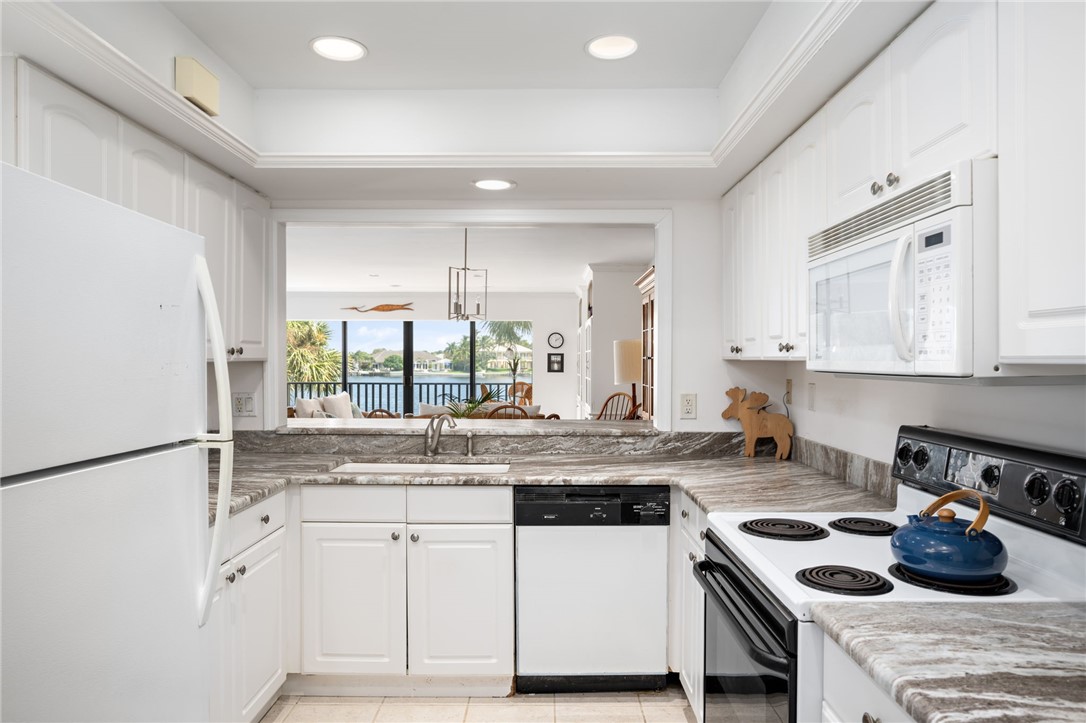 1870 Bay Road, Unit 213G Vero Beach, FL 32963 - Photo 10 of 36 a kitchen with stainless steel appliances granite countertop a sink stove and refrigerator