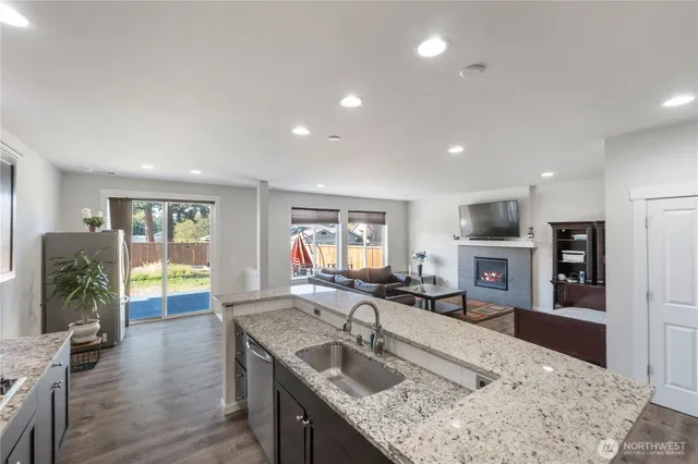a view of kitchen island a sink and a large window