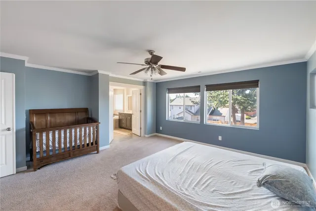 a bed sitting in a spacious bedroom next to a window
